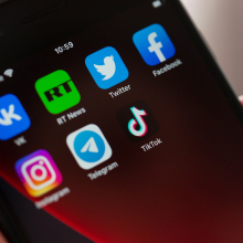 The home screen of a smart phone shows icons for social media apps and Russia Today.