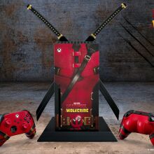 An Xbox Series X console and controllers themed with Deadpool's costume design, featuring Deadpool's katanas on the console. Promotional image for the movie 'Deadpool & Wolverine' in theaters July 26, by Marvel Studios
