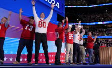 grown men in football jerseys on the DNC stage, all former players for Tim Walz