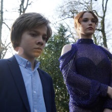 A young boy and his stepmother at an outdoor funeral.