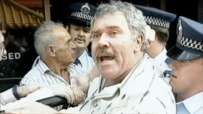 Jack Karlson being escorted to a car by police in the viral "democracy manifest" video.