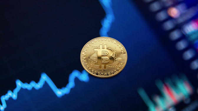 Gold bitcoin coin on blue background