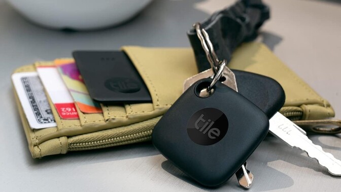 a tile tracker is attached to a set of keys next to a canvas wallet