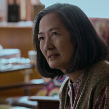 An older woman sits in a room.