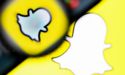 A snapchat logo with a magnifying glass and a phone hovering over it. 