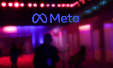 the Meta logo on a wall with a blurry reflected background