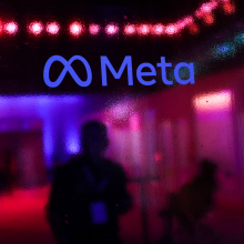 the Meta logo on a wall with a blurry reflected background