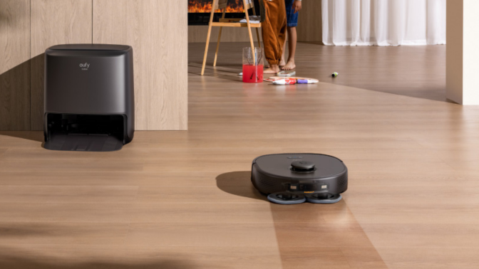 Eufy X9 Pro robot vacuum mopping hardwood floor with dock and family in background
