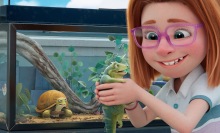 A red-headed girl holds a pet lizard. 