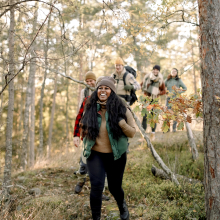 a group of people hiking in nature while all wearing packs and fall clothing