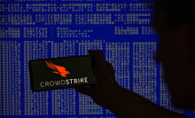 crowdstrike logo on phone in front of screen of code