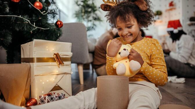 Photo of happy little girl enjoying with her new toy during holidays.