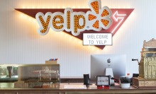 The entry to Yelp's office in San Francisco, with a Yelp logo behind a large reception desk.