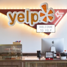 The entry to Yelp's office in San Francisco, with a Yelp logo behind a large reception desk.