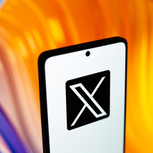 x logo on phone with colorful background