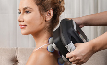 Electric massager being used on back.