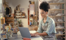 Laptop, pottery studio and woman typing ceramic sales website