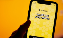 bumble app with yellow background and MAKE THE FIRST MOVE text displayed on iphone in front of orange background