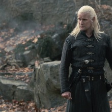 Daemon Targaryen stands in the courtyard at Harrenhal, one hand on his sword.