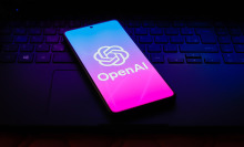 The OpenAI logo is displayed on a smartphone screen.