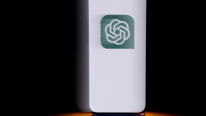A phone displays a green OpenAI logo.