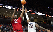 DJ Burns, Jr. of the NC State Wolfpack shoots over Jordan Minor of the Virginia Cavaliers in the first half during a game at John Paul Jones Arena on January 24, 2024, in Charlottesville, Virginia.