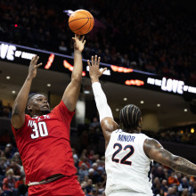 DJ Burns, Jr. of the NC State Wolfpack shoots over Jordan Minor of the Virginia Cavaliers in the first half during a game at John Paul Jones Arena on January 24, 2024, in Charlottesville, Virginia.