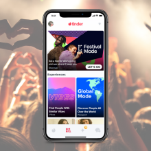 A composite image of a stock music festival photo behind a phone showing Tinder's Festival Mode.