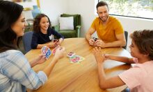 A family plays UNO around a table