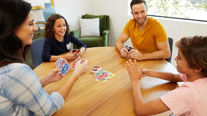 A family plays UNO around a table