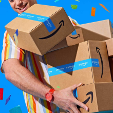 a man holding amazon boxes against a blue background filled with confetti