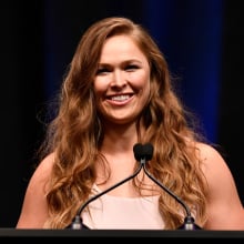 ronda rousey standing at a lectern