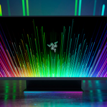 the razer raptor 27 against a shadowy rainbow background