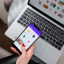 woman holding phone in front of laptop