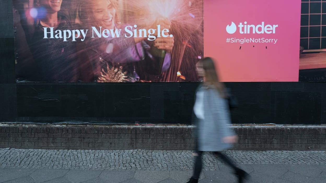 A young woman walks past a billboard advertisement for the dating app Tinder on February 18, 2019 in Berlin, Germany.