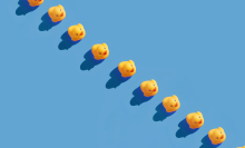 Yellow rubber ducks in a line on blue background.