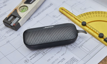 Black blueetoth speaker on a desk with a ruler and protractor