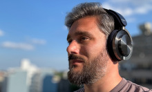 man wearing the dyson ontrac headphones against blue sky