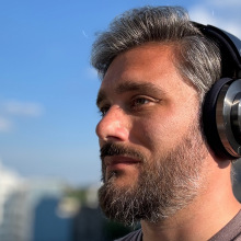 man wearing the dyson ontrac headphones against blue sky