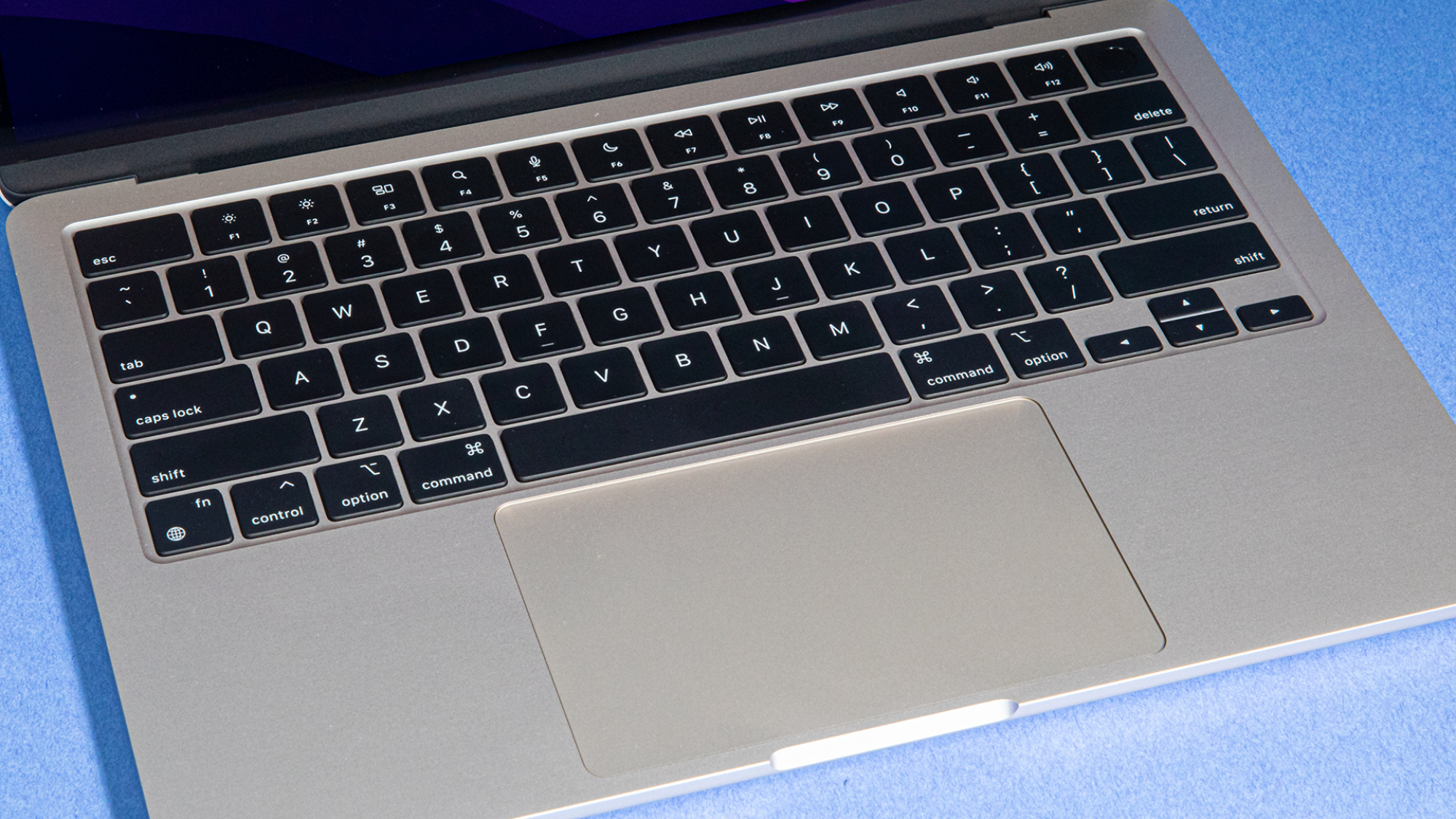 View of the 2022 M2 MacBook Air keyboard against a blue surface