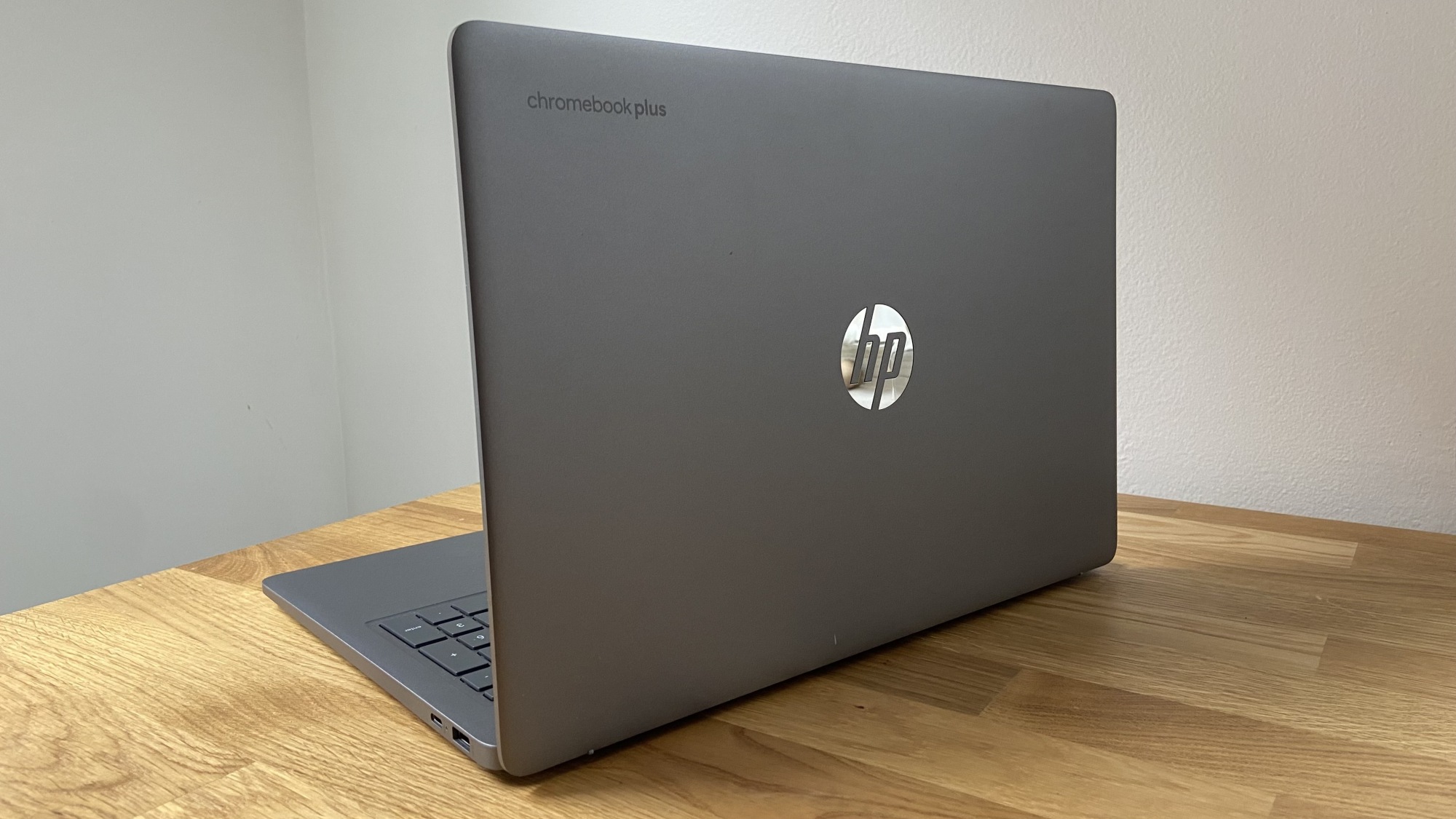 a rear view of the hp chromebook plus 15.6-inch on a wooden surface