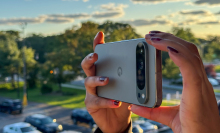 The Pixel 9 Pro XL being held horizonally as someone appears to take a photograph.