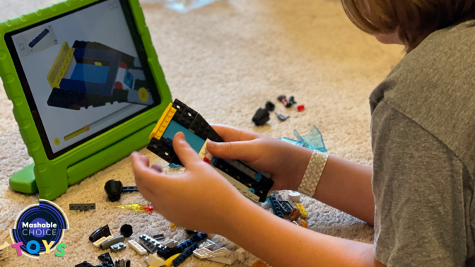 kids building lego bricks following instructions on tablet