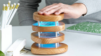 person touching long distance touch lamp with blue light