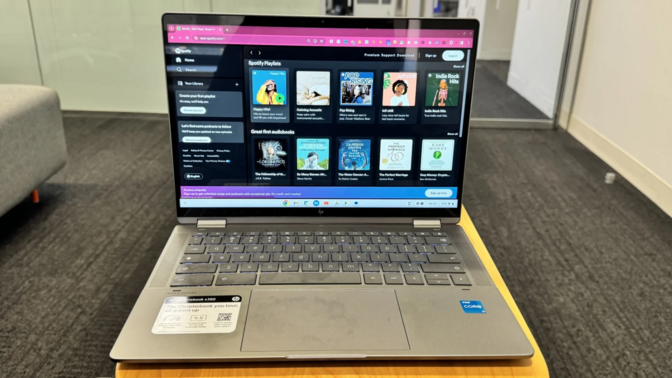 the HP Chromebook Plus x360 14c on a small wooden table inside an office