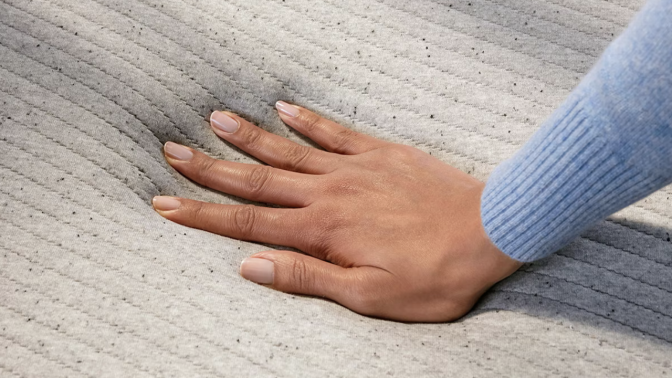 Person touching memory foam mattress