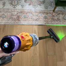 Person's hand holding Dyson V12 Detect Slim cordless vacuum