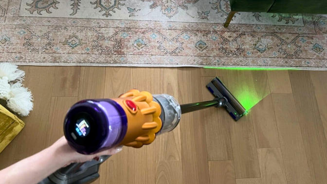 Person's hand holding Dyson V12 Detect Slim cordless vacuum