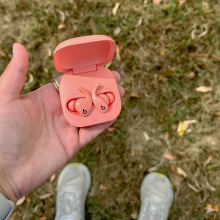 A person holding a pair of Beats Fit Pro against a lawn