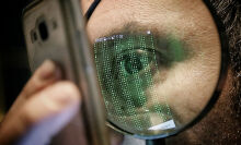 Closeup of a person's eye and face as they look at a smartphone screen. 